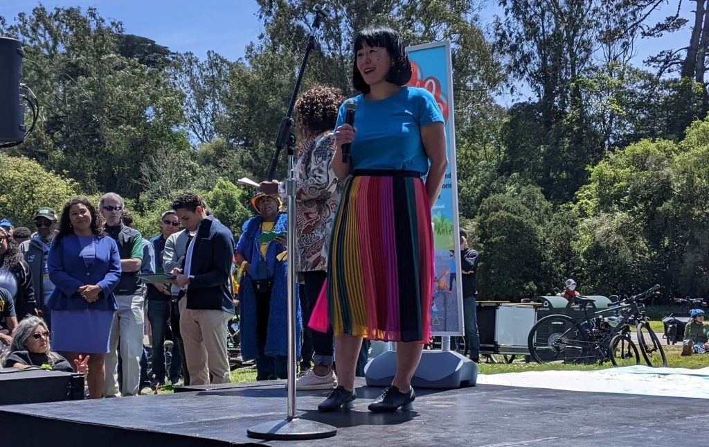 At the May 7 signing of the JFK Promenade legislation, Lian Chang spoke on behalf of the many parents who pushed for a permanent car-free JFK. Photo by Walk SF.