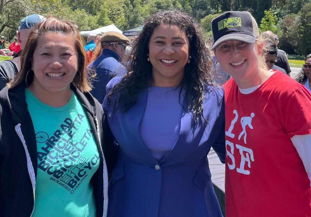 Janelle Wong, executive director of the San Francisco Bicycle Coalition, Mayor London Breed, and Marta Lindsey with Walk SF at the signing of the JFK Promenade legislation. Photo by Walk SF.