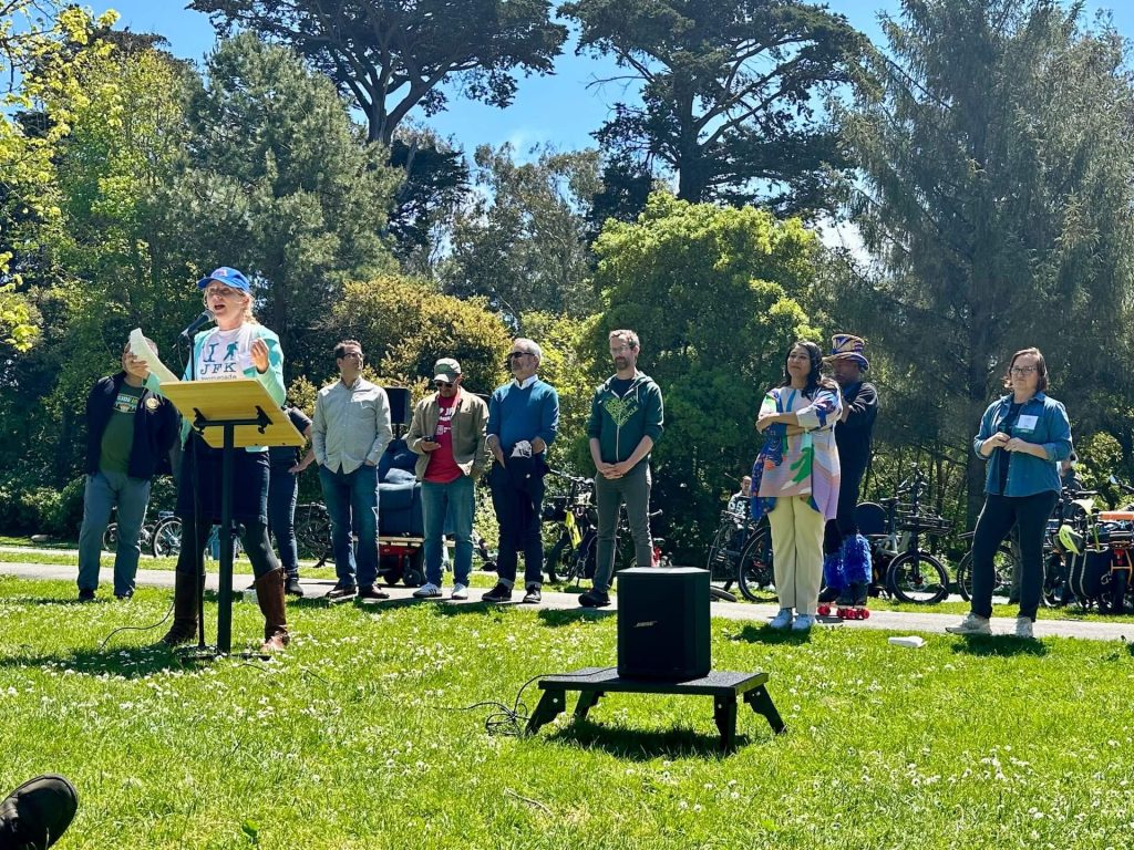 Walk SF Communications Director Marta Lindsey speaking at the JFK Promenade's 4th Anniversary Community Picnic.