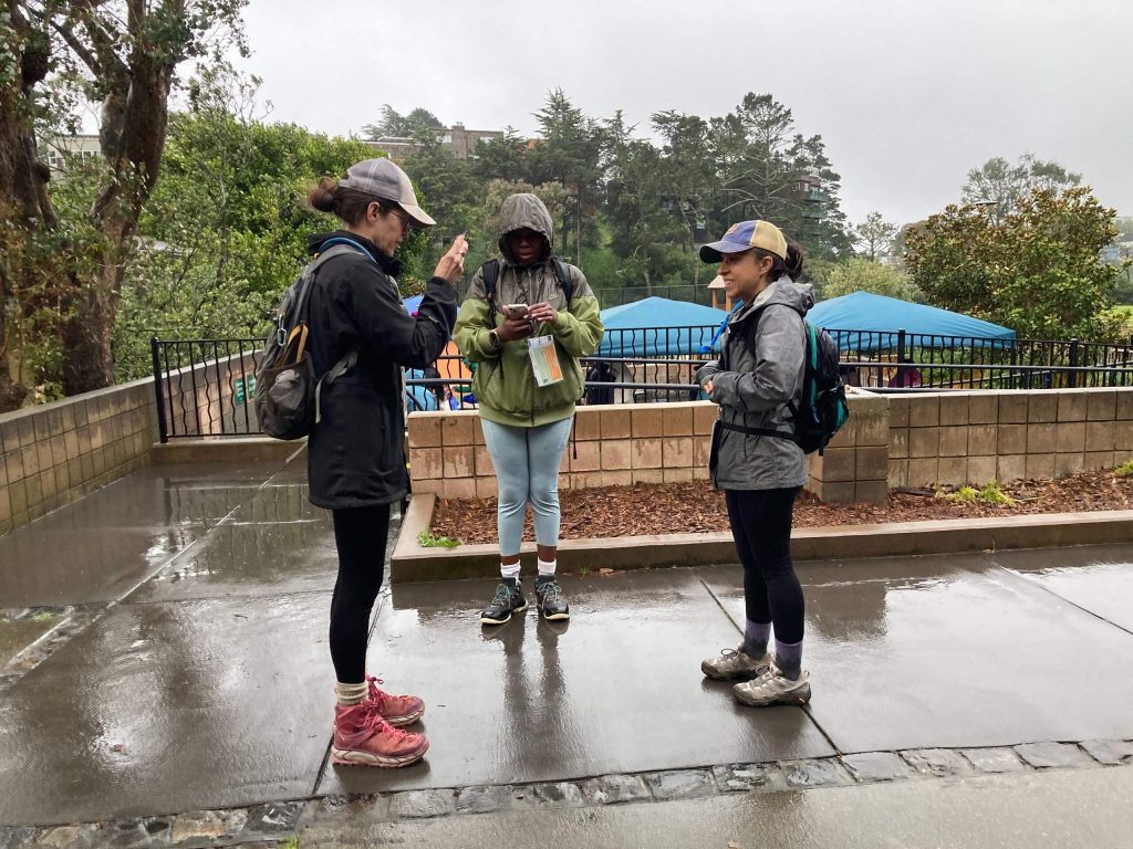 A group of three stand in a circle talking to each other.