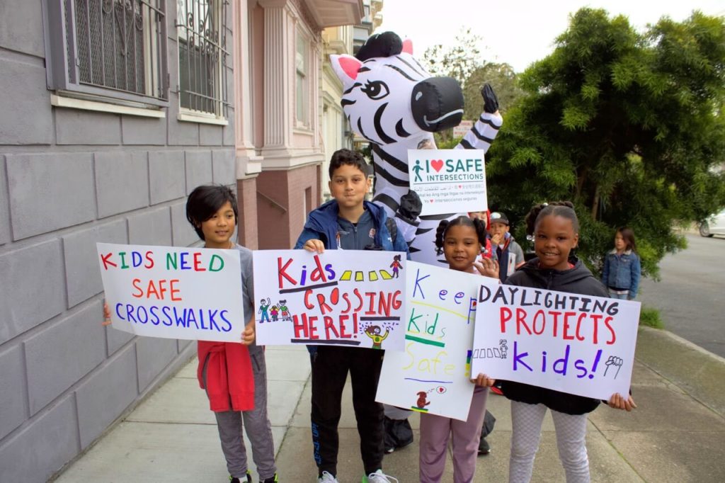 Students from New Traditions Elementary School pose with Zoe the Zebra. Photo by Fiona Yim. 