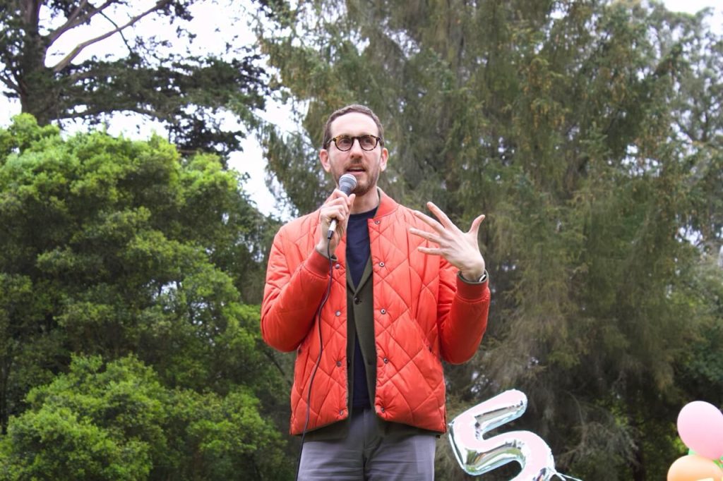 State Senator Scott Wiener spoke at the picnic. Back in 2020, Senator Wiener authored and passed a state bill streamlining the approval process for pedestrian, bike, and transit projects that was crucial in JFK Promenade becoming permanent. Without this bill, JFK Promenade would likely have been put into legal limbo. Photo by Fiona Yim. 